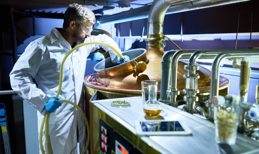 Brewing bearded man in brewery cleaning over ingredients