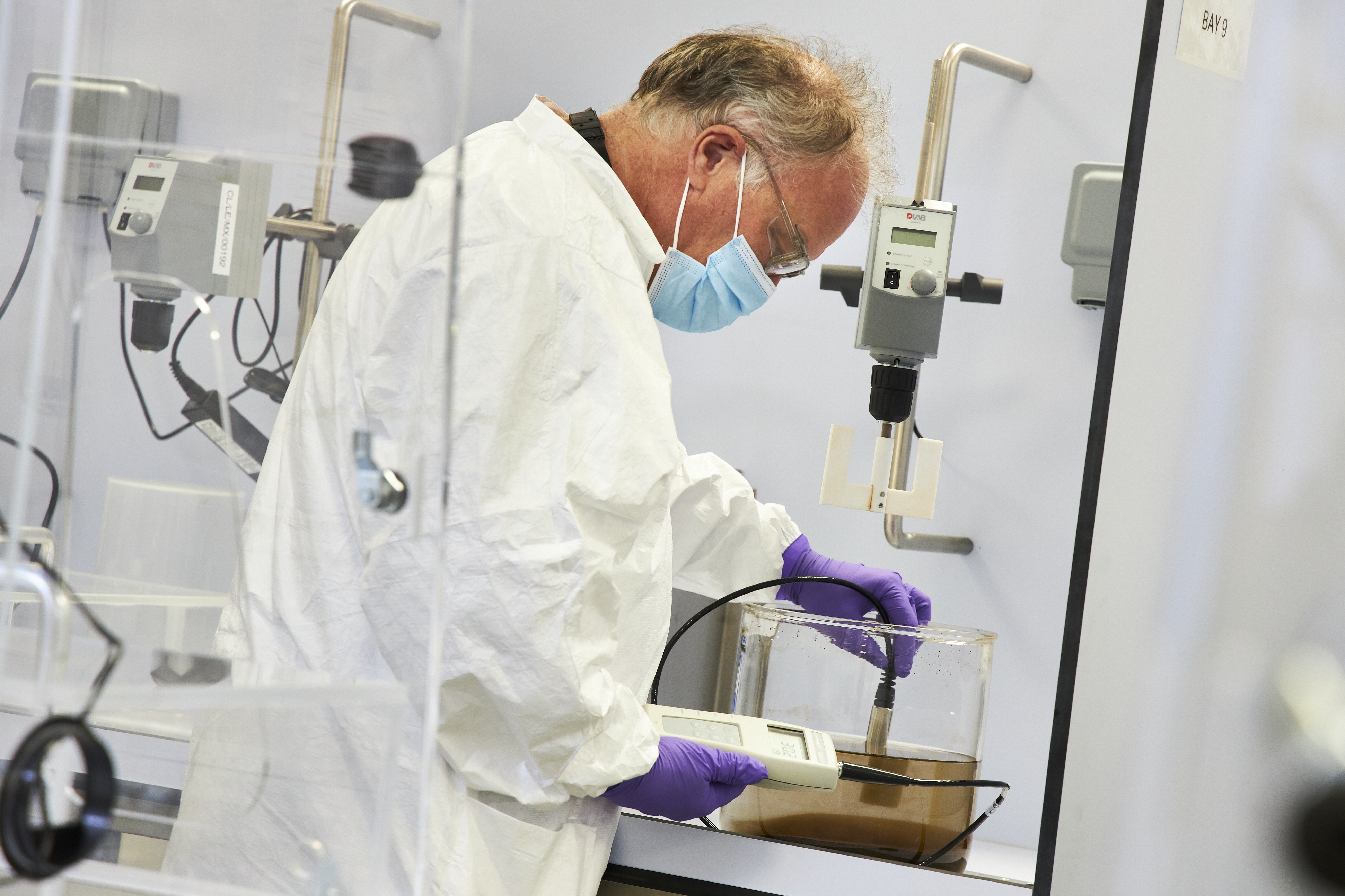 Scientist handling Sera-Mag equipment - side view, close up, mask on, angled 2 (high res)