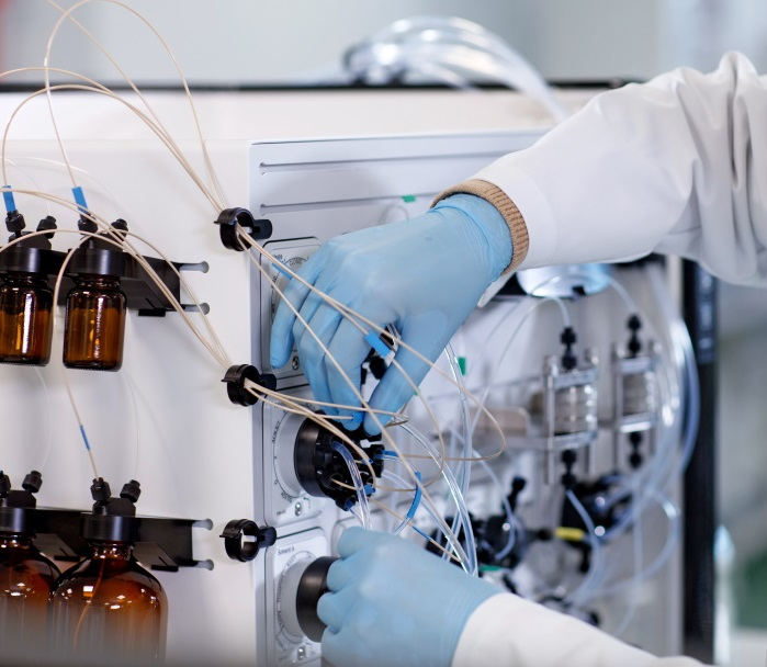 Close-up of a scientist working with ÄKTA oligosynt oligonucleotide synthesizer