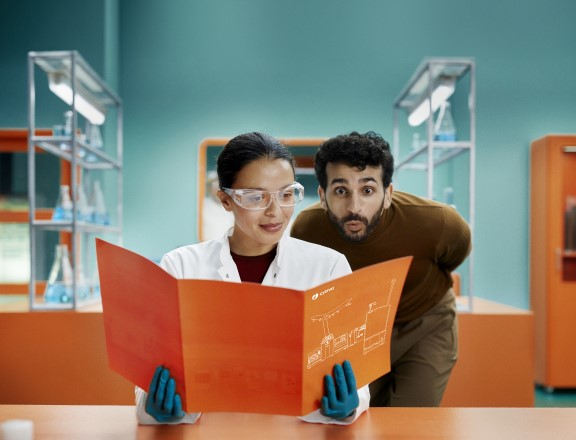 Scientist and Cytiva man reading a Sefia cell therapy manufacturing platform brochure in a lab